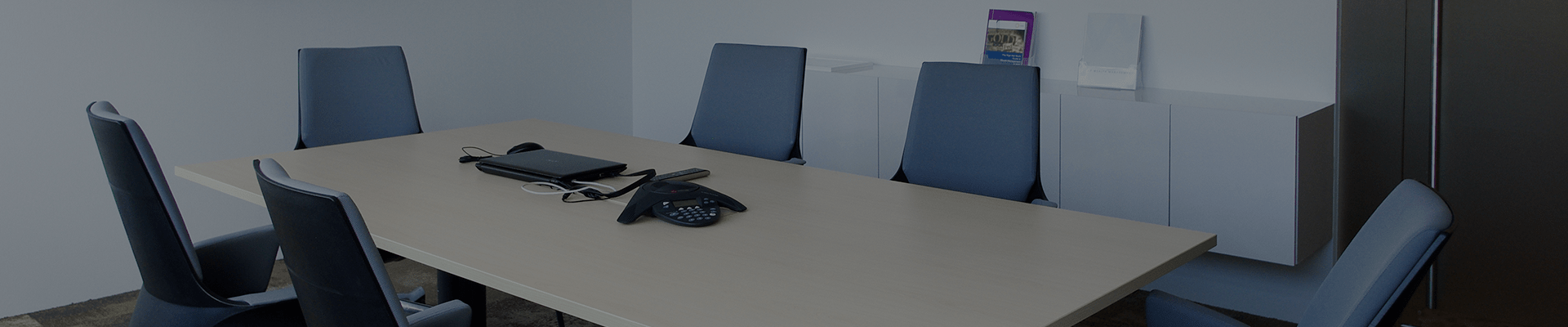 6 empty chairs around a meeting table